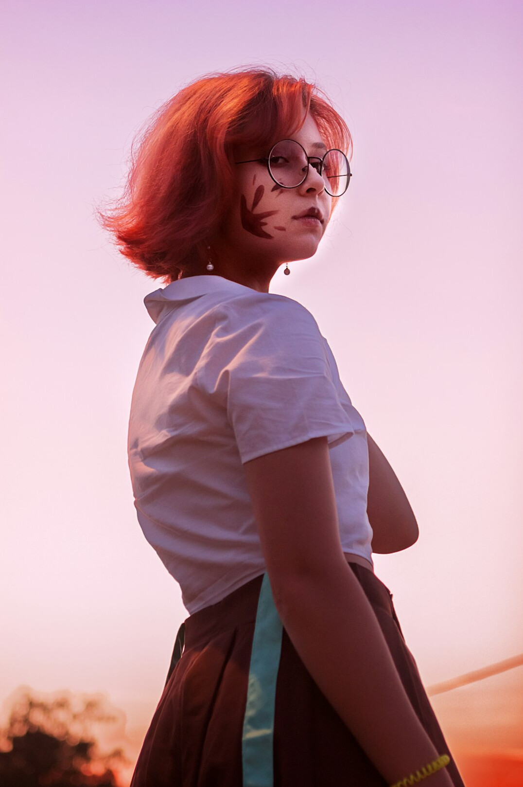 Studio portrait of a woman with a short red-brown bob haircut and glasses